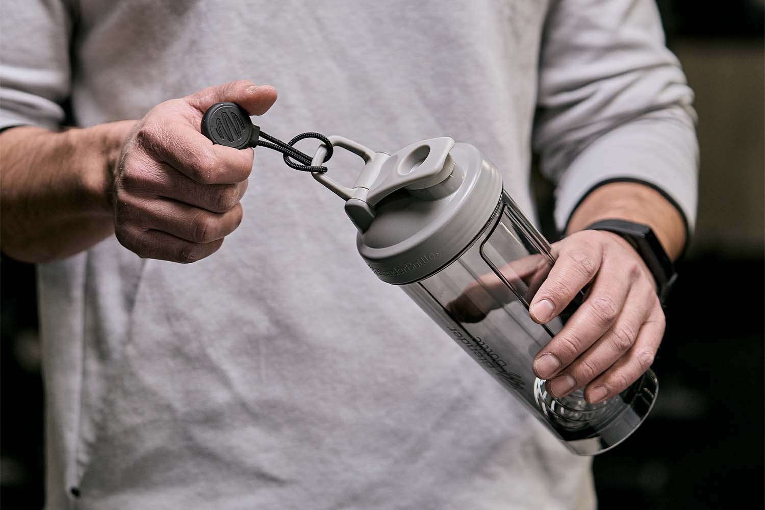 Man holding a BlenderBottle with an attached hanging magnet