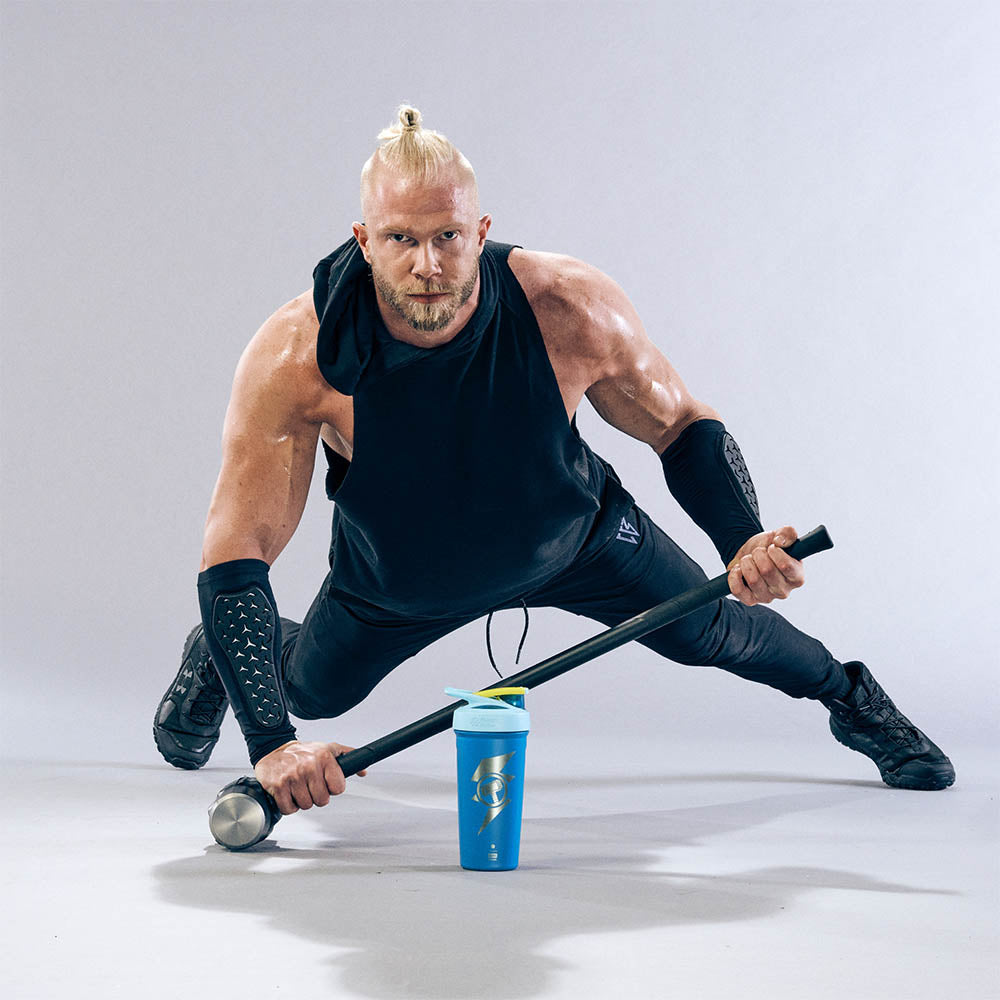Man who looks like Thor working out with a insulated stainless steel Thor shaker bottle