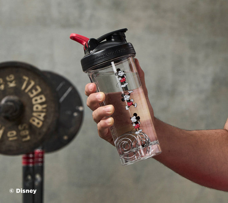 Mickey Mouse Protein Shaker Bottle being held up in the gym. BlenderBottle - Mickey & Minnie - Pro Series - Mickey Mouse | Color#Mickey Mouse_Size#28oz