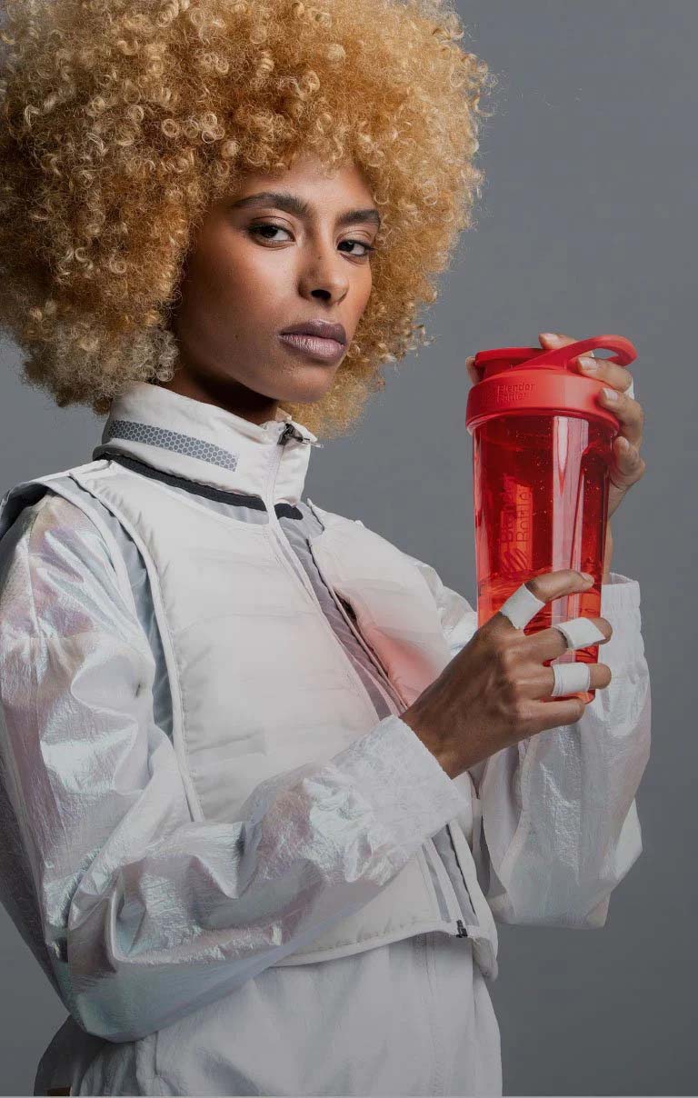 Woman holding a BlenderBottle brand shaker bottle