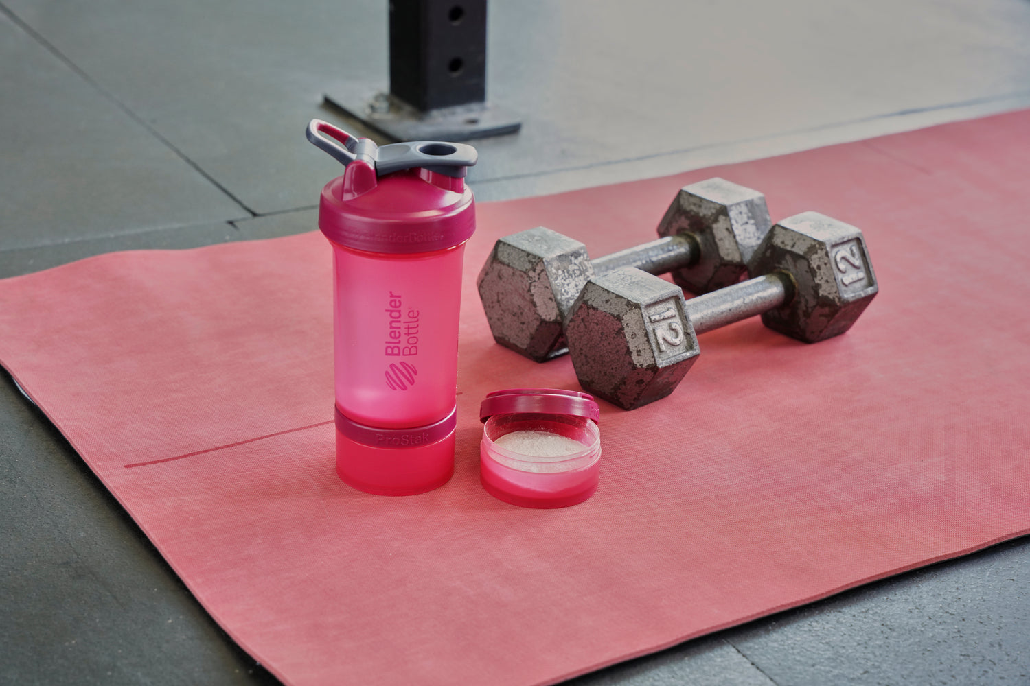 Protein powder in a BlenderBottle ProStak jar.