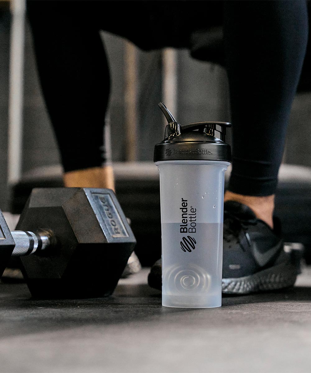 Large Classic 45oz shaker bottle in the gym. A man is working out in the background.