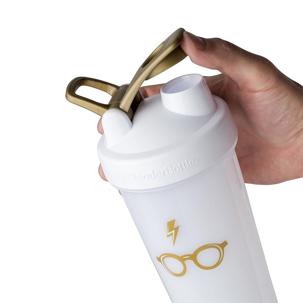 Hand using Harry Potter shaker bottle. The thumb being kept off the drinking spout because of the shaker cups spout guard.