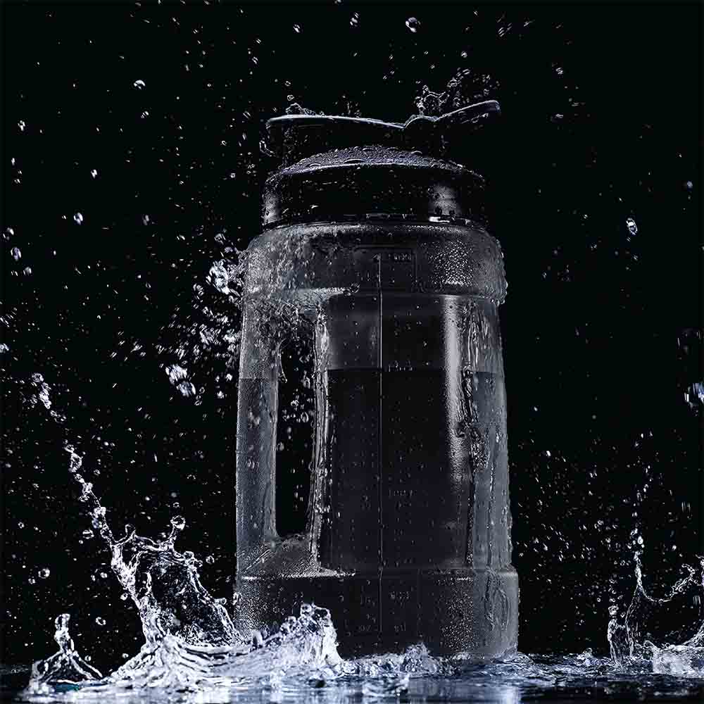 Koda Water Jug in Black splashing in water on a black background