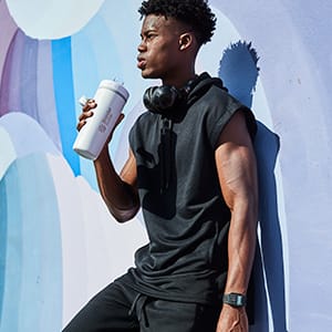 Man drinking from insulated protein shaker cup