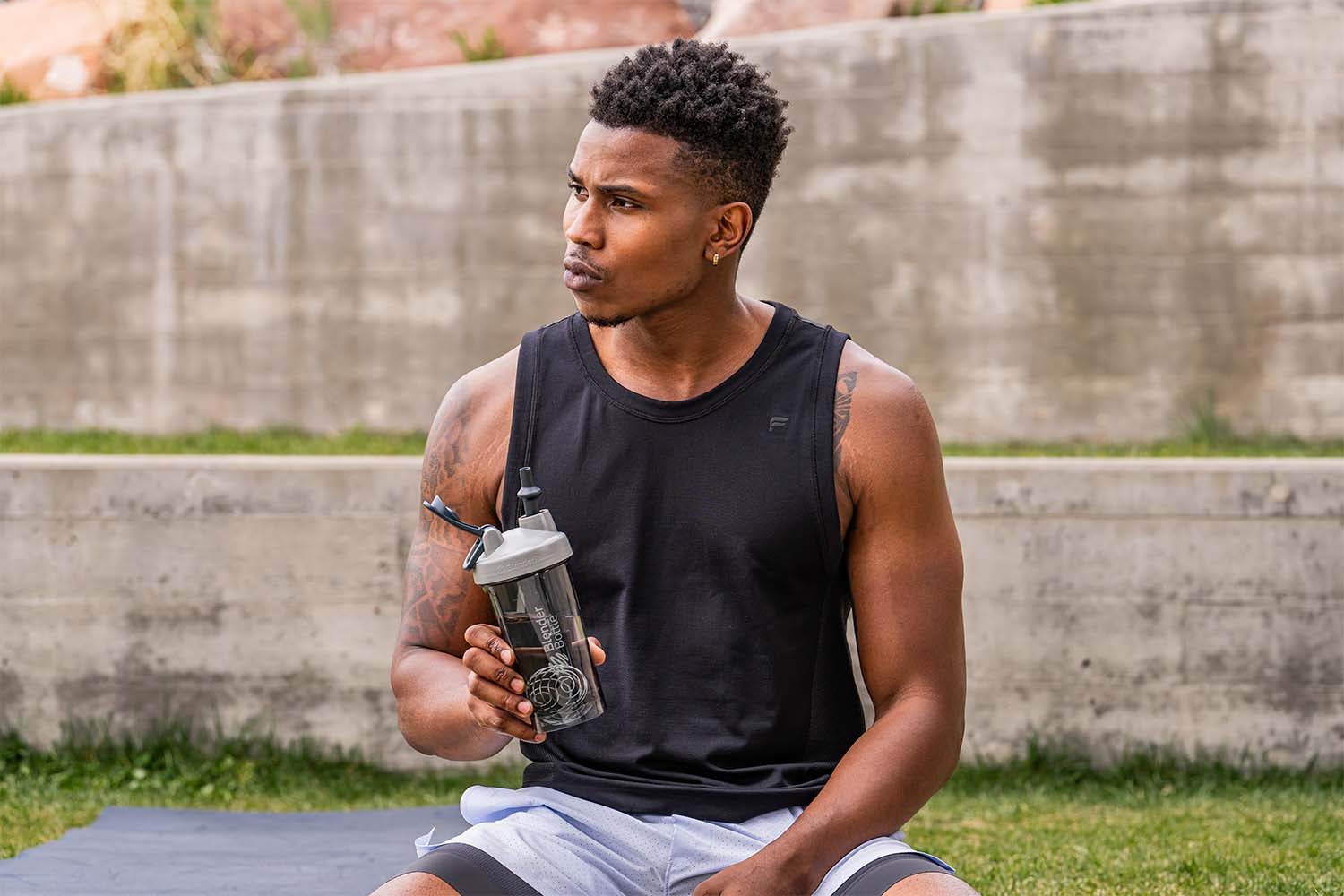 Man holding shaker bottle with a Blender Bottle straw