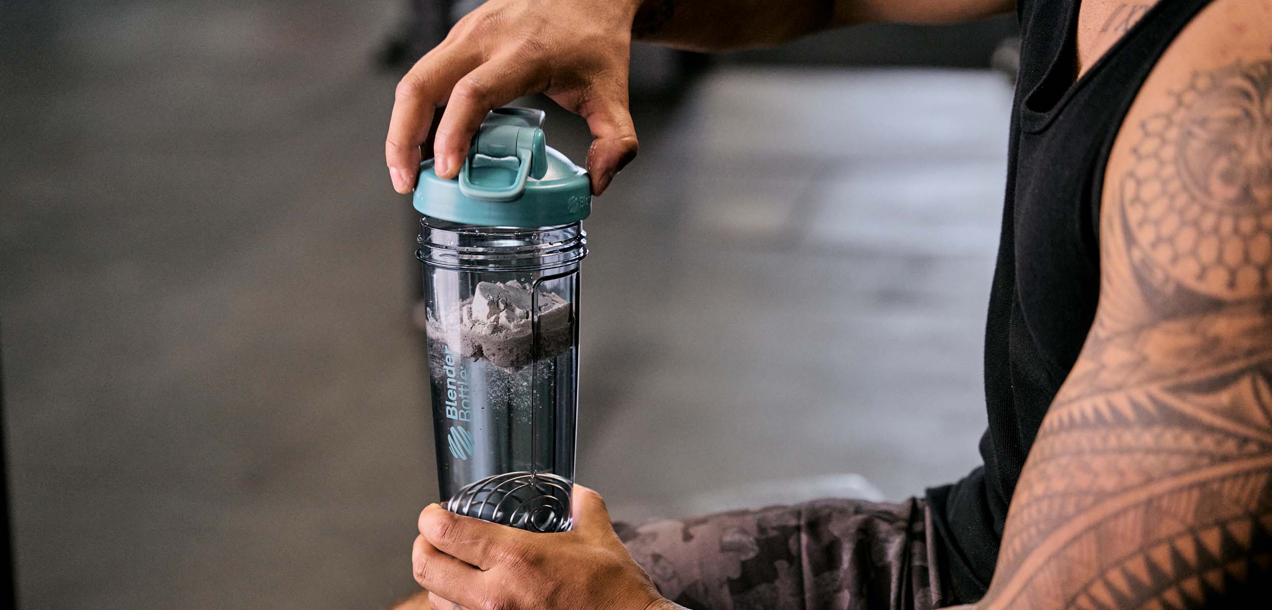 Man mixing protein in a Blender Bottle shaker bottle