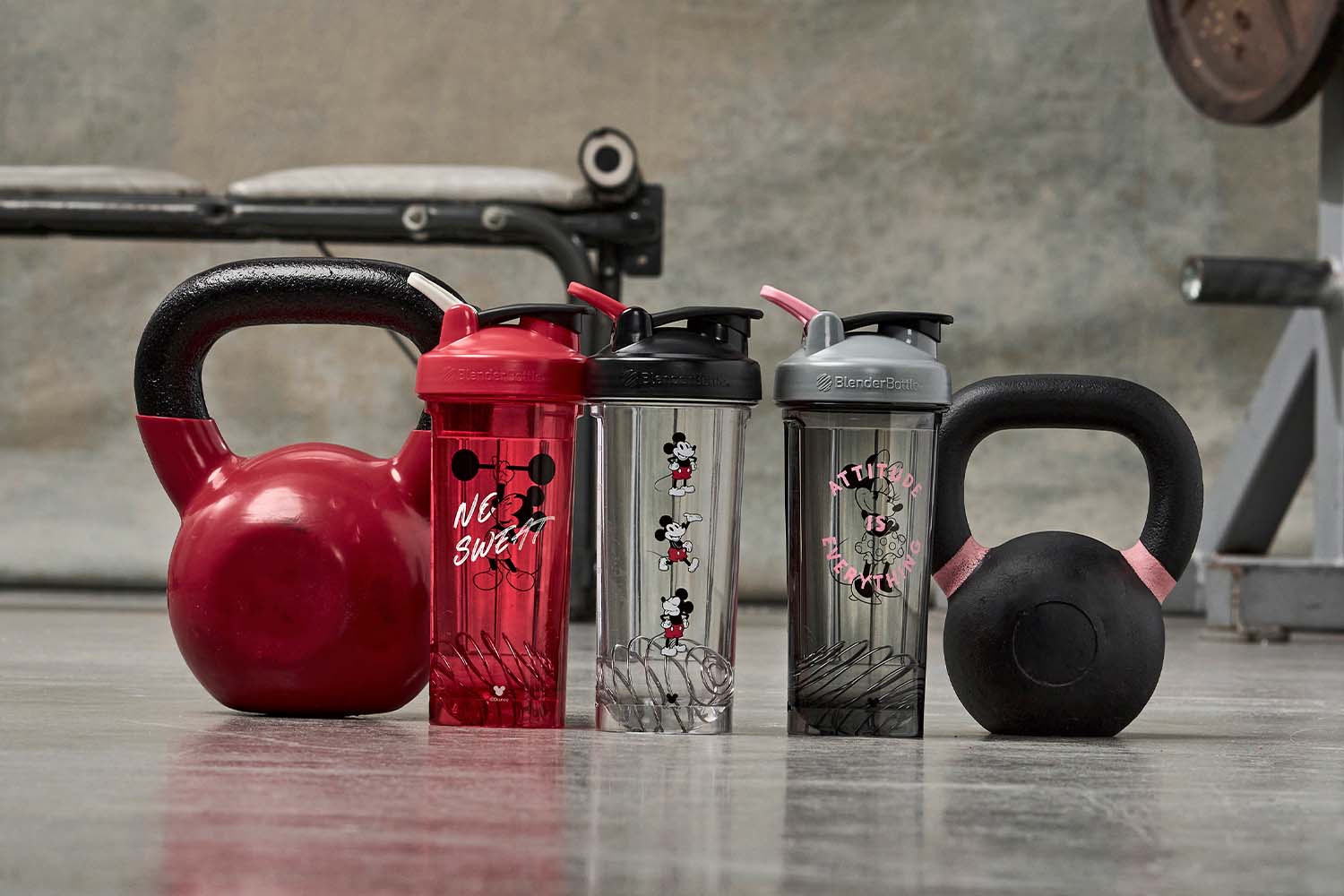 Mickey Mouse shaker bottles and a Minnie Mouse shaker cup sitting on the gym floor