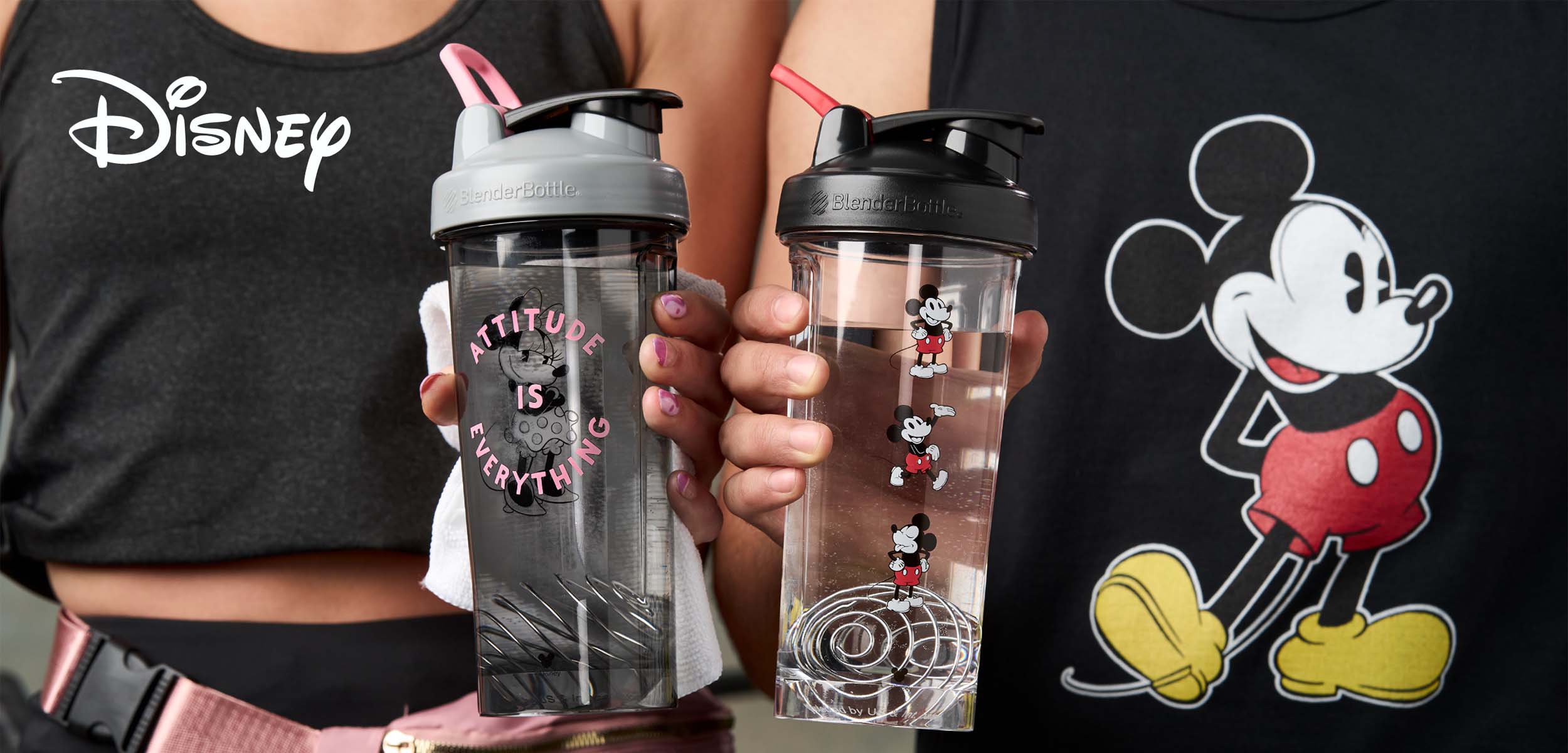 Man and woman holding Mickey and Minnie protein shaker cups