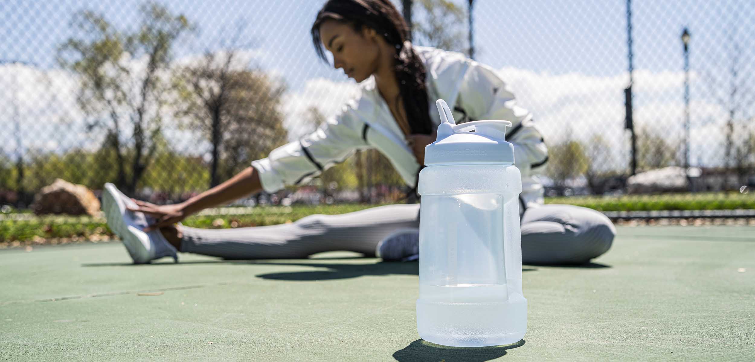 https://www.blenderbottle.com/cdn/shop/files/Woman_Sitting_with_Koda_Water_Jug.jpg?v=1678228490&width=2500